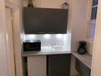 a small kitchen with a sink and a microwave at Appartement rez de chaussée Gold beach in Bayeux