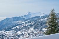 a snow covered mountain with a town in the foreground at Chalet Le Lapye in Les Gets