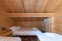 a room with two beds in a wooden cabin at Chalet Le Lapye in Les Gets