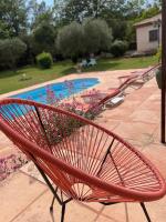 a red chair sitting next to a swimming pool at Le calme de la campagne proche de tout..... in Les Arcs sur Argens