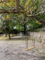 a swing hanging from a tree in a park at Le calme de la campagne proche de tout..... in Les Arcs sur Argens