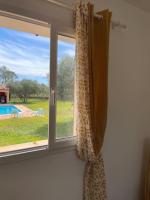 a window with a curtain and a view of a yard at Le calme de la campagne proche de tout..... in Les Arcs sur Argens