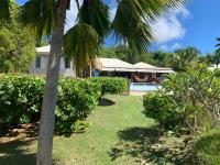 a house with a swimming pool and a palm tree at Villa Libellule in Grand-Bourg