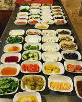 マルディンにあるCARRA KONAĞIのさまざまな種類の食べ物が入った白い皿が置かれたテーブル