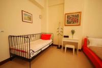 a room with a crib and a bed and a table at Green Window Homestay in Hualien City