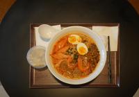 uma tigela de sopa com ovos em uma bandeja em Poltton Century Hotel em Huizhou