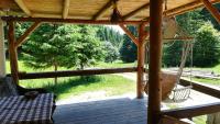 a porch with a hammock and a swing at Cabana Pietricica in Dîmbovicioara