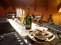 a table with two glasses of wine and a bottle of oysters at Lodjadis in Labaroche