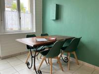 a wooden table with green chairs in a room at COC - La Belle Etoile in Wissant