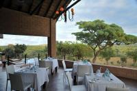 a restaurant with white tables and chairs and a tree at Zwahili Private Game Lodge & Spa in Modimolle