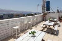 eine Terrasse mit Stühlen und Tischen auf dem Dach in der Unterkunft Little Prince Hostel-5 Min Walk To The Beach in Eilat