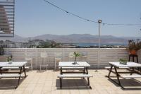 eine Terrasse mit Tischen und Stühlen auf dem Dach in der Unterkunft Little Prince Hostel-5 Min Walk To The Beach in Eilat