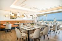 a restaurant with tables and chairs and a view of the ocean at Hotel Benalma Costa del Sol in Benalmádena