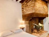 a bedroom with a bed and a brick fireplace at Le Pandora, Charmant Studio - Hypercentre in Rennes