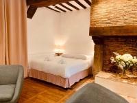 a bedroom with a bed and a brick fireplace at Le Pandora, Charmant Studio - Hypercentre in Rennes