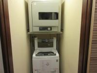 a microwave and a television on top of a washing machine at Homey House in Taipei