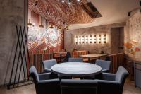 a restaurant with tables and chairs and a mural at Ведмежа гора Family Resort & Spa in Yaremche