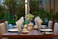 a wooden table with white plates and napkins on it at Hotel Thrive, A Tropical Courtyard in Kathmandu