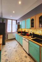 Il comprend une cuisine avec des placards bleus et du carrelage. dans l&#39;établissement La Note Verte Pause en ville, à Foix