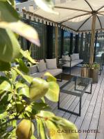 un patio con sofás y una sombrilla en un edificio en Castelo Hotel, en Chaves