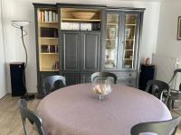 a dining room with a table with chairs and a book shelf at Appart Hypercentre Biarritz - PKG &#47; WIFI &#47; 4-6 Personnes in Biarritz