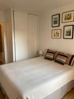 a bedroom with a large white bed with three pillows at Appart Hypercentre Biarritz - PKG &#47; WIFI &#47; 4-6 Personnes in Biarritz