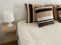 a bedroom with a bed with a lamp and pillows at Appart Hypercentre Biarritz - PKG &#47; WIFI &#47; 4-6 Personnes in Biarritz