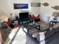 a living room with a couch and chairs and a television at Appart Hypercentre Biarritz - PKG &#47; WIFI &#47; 4-6 Personnes in Biarritz