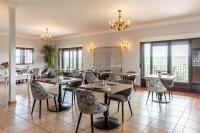 ein Restaurant mit Tischen, Stühlen und Fenstern in der Unterkunft CASA RURAL Cigarral del Pintor in Toledo