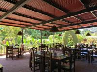 a restaurant with tables and chairs under a roof at Hotel Tiosh Abaj in Santiago Atitlán