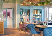 Habitación con paredes azules, mesas y sillas. en Beach Apartments Büsum, en Büsum