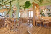 Un restaurante con mesas y sillas y un bar. en Beach Apartments Büsum, en Büsum