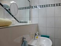 a white bathroom with a sink and a mirror at Pension Maiglöckchen in Karlshagen