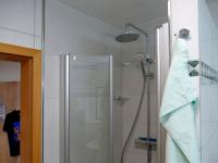 a shower with a glass door in a bathroom at Pension Maiglöckchen in Karlshagen