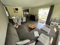 una sala de estar con un sofá y una mesa en Forest Family 6 persoons op 5 sterren park, en Beekbergen