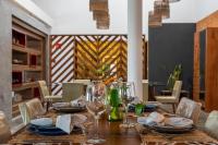 a wooden table with plates and glasses on it at Villa Pantai Milagres Exclusive Hotel in São Miguel dos Milagres