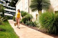a woman in a yellow bikini walking down a sidewalk at Sheraton Dubrovnik Riviera Hotel in Mlini