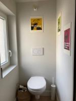 a white bathroom with a toilet and a window at Studio du Onze Charmant studio avec chambre en mezzanine centre Montfort L&#39;Amaury in Montfort-lʼAmaury