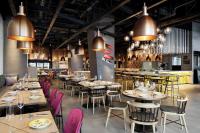 Un restaurante con mesas, sillas y luces. en Aloft Osaka Dojima, en Osaka