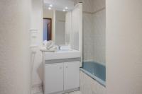 a white bathroom with a sink and a mirror at Bel appartement 6 couchages au plan d&#39;eau d&#39;Embrun in Embrun