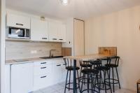 a kitchen with white cabinets and a wooden counter top at Bel appartement 6 couchages au plan d&#39;eau d&#39;Embrun in Embrun