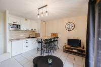 a kitchen with a table and stools in a room at Bel appartement 6 couchages au plan d&#39;eau d&#39;Embrun in Embrun