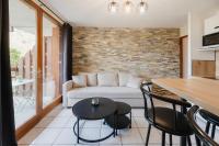 a living room with a couch and a table and chairs at Bel appartement 6 couchages au plan d&#39;eau d&#39;Embrun in Embrun