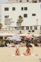 Dos mujeres en traje de baño sentadas en la playa en 180 Boutique Hostel, en Tel Aviv