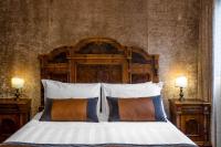 a bedroom with a bed with a wooden headboard and two lamps at Palazzo Bembo - Exclusive Accommodation in Venice