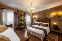 a hotel room with two beds and a desk at Palazzo Bembo - Exclusive Accommodation in Venice