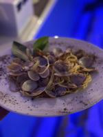 een bord met mosselen en pasta erop bij San Antonio Beach Guesthouse & Restaurant in Kata Beach