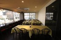 una fila de mesas y sillas en un restaurante en Hotel Green Line, en Sendai