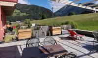 Un patio con mesa y sillas y una valla. en Hotel Pariente, en Schladming