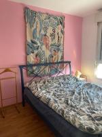 a bedroom with a bed with a painting on the wall at Grand appartement F3 - Centre- ville Le Bourget in Le Bourget